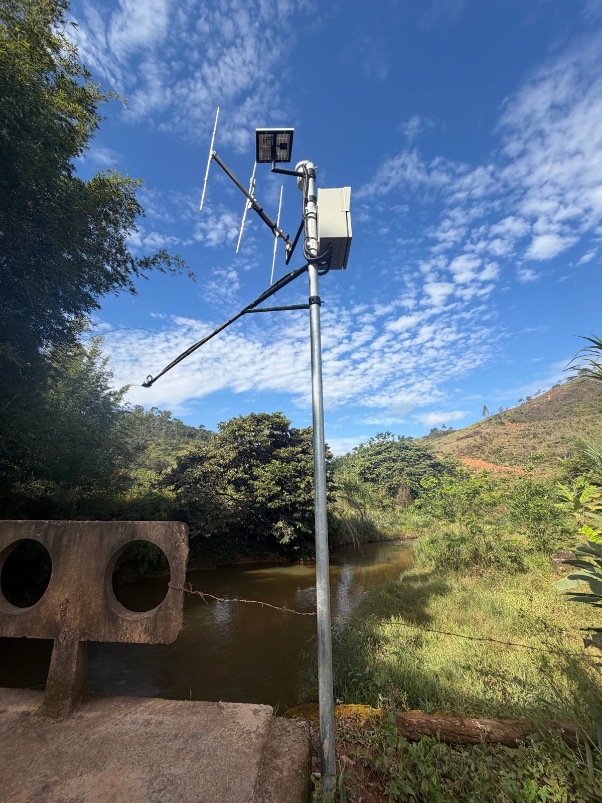 Figura 1: Estação de monitoramento na Ponte Cachoeira do Brumado, com placa solar e antena de rádio.